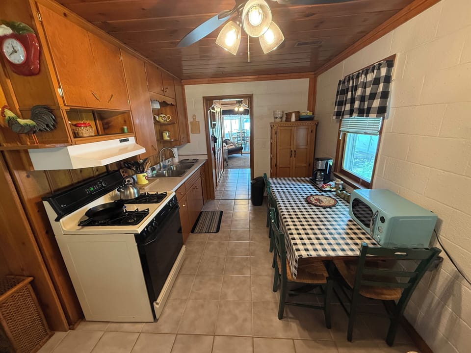 Kitchen - fully stocked with cookware, utensils, and dishes. With a table.
