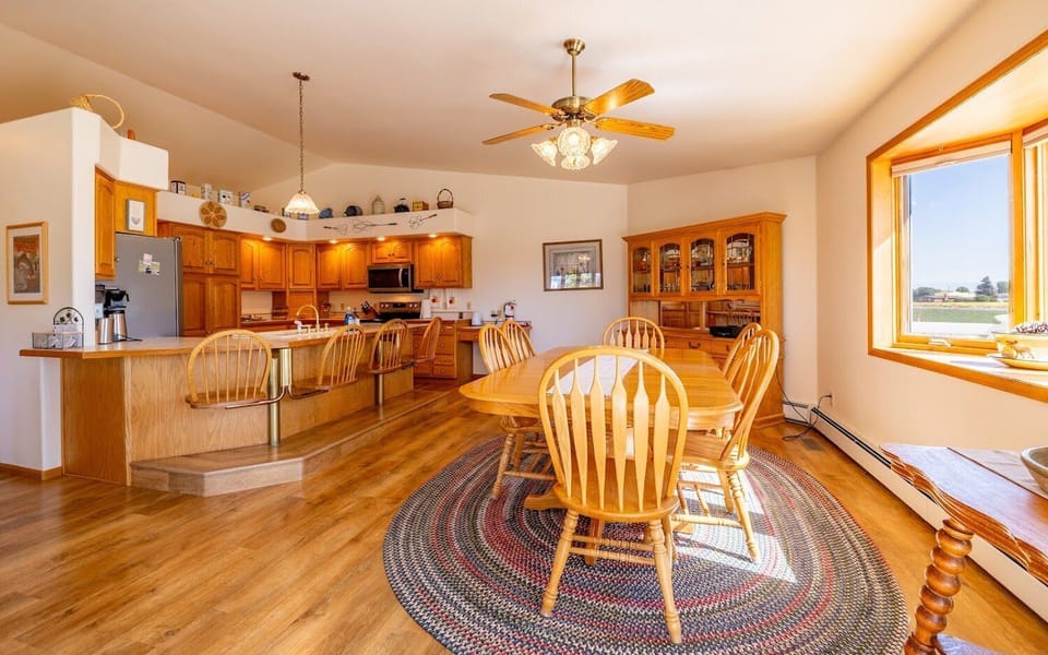 Sunny dining room with picture windows and access to the back patio space.