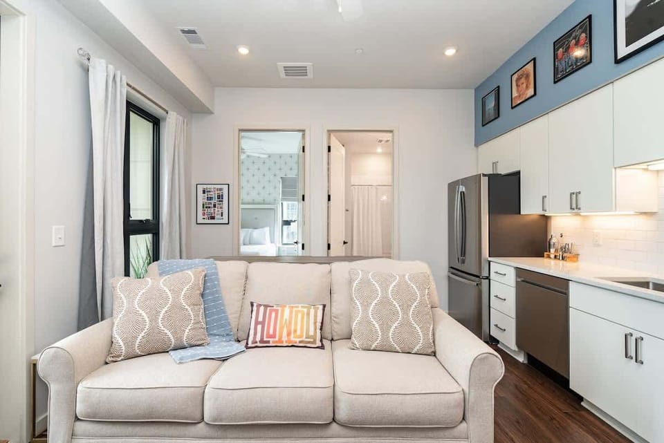 Open floor, bright and inviting living space featuring a smart TV and cozy furnishings with a private balcony.