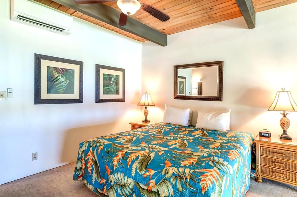 Charming loft retreat with a tropical bedspread, wood accents, warm lighting, and balcony views over the greens NAP-C42