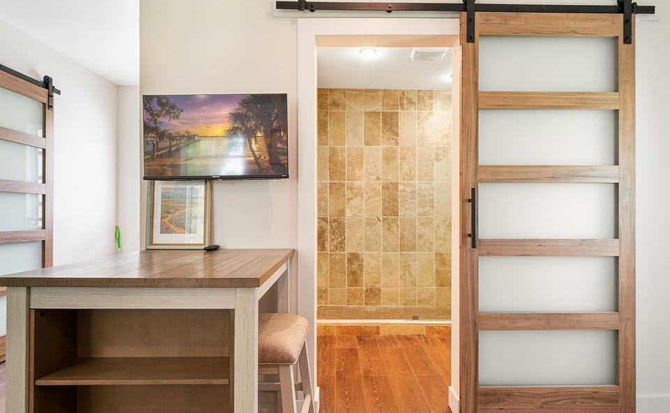 First Cottage -  A versatile interior space featuring a stylish sliding barn door and convenient built-in shelving, combining aesthetics with functionality.
