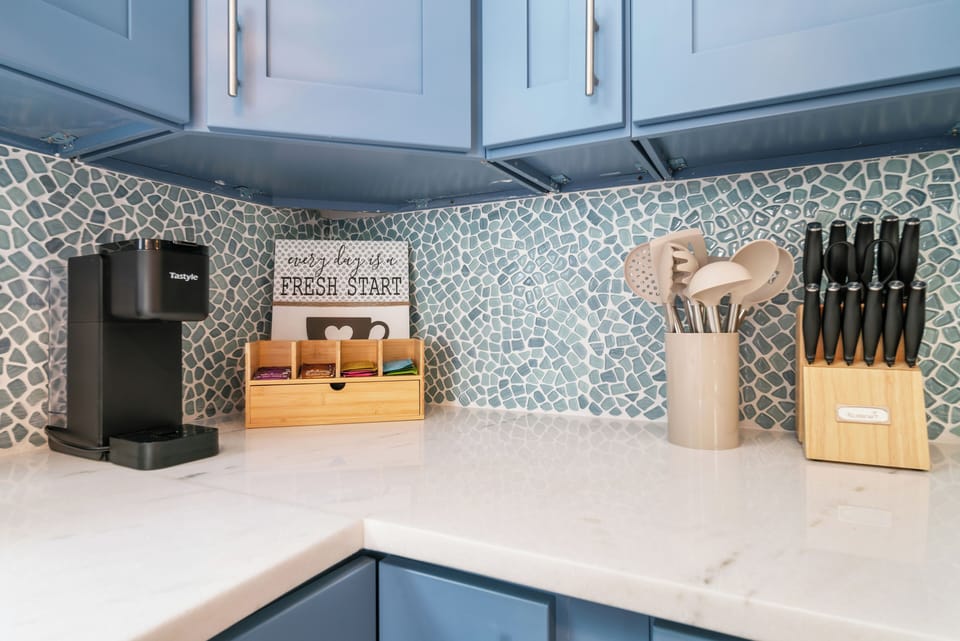 Coffee station with pod maker, bamboo tea organizer & full knife block on marble counters — everything you need for a slow morning in