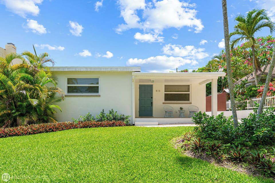 Admire the classic curb appeal of this property, set on a verdant lawn with lush landscaping, offering a serene welcome.
