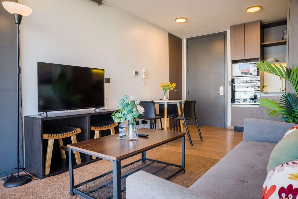 Cozy living area with modern decor, perfect for relaxing after exploring the city. Enjoy a movie night on the flat-screen TV.