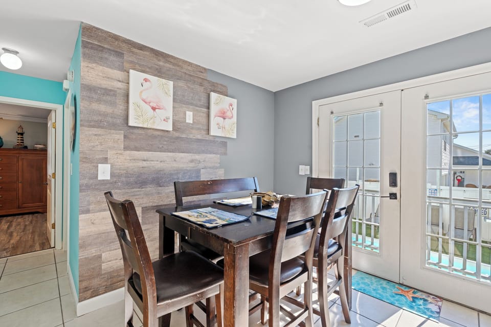 Gather around your stylish dining table for memorable meals with loved ones in this inviting coastal-themed space.