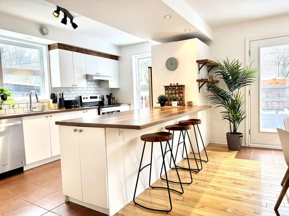 Cuisine moderne : un espace lumineux et élégant avec des appareils contemporains et un comptoir accueillant, parfait pour cuisiner, discuter et partager des moments conviviaux.