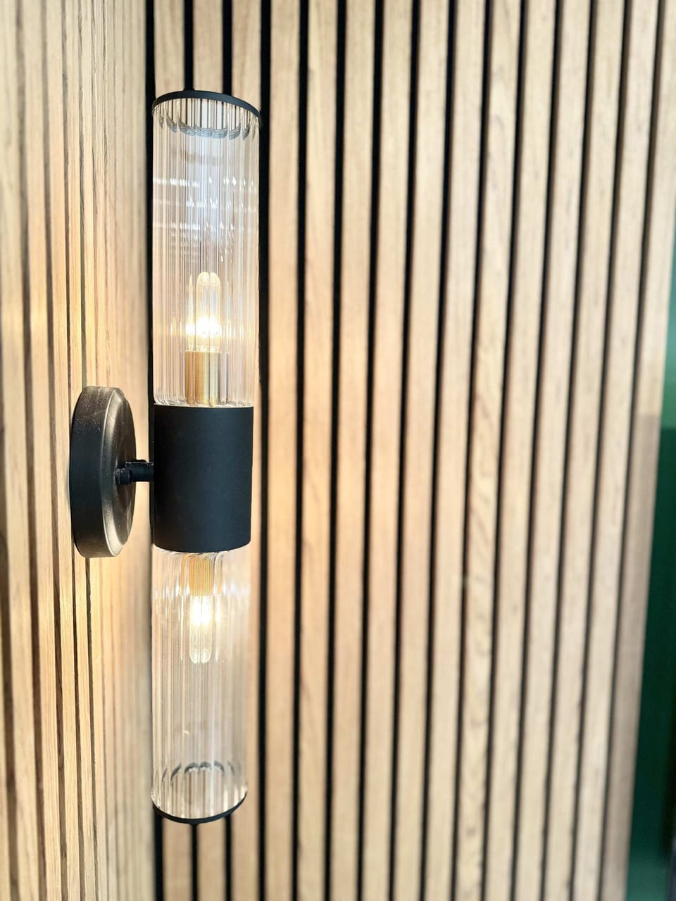 Apporter de la chaleur et une touche d'élégance contemporaine au mur. Les lignes verticales du bois et le design élégant du luminaire créent un accent harmonieux et stylé.