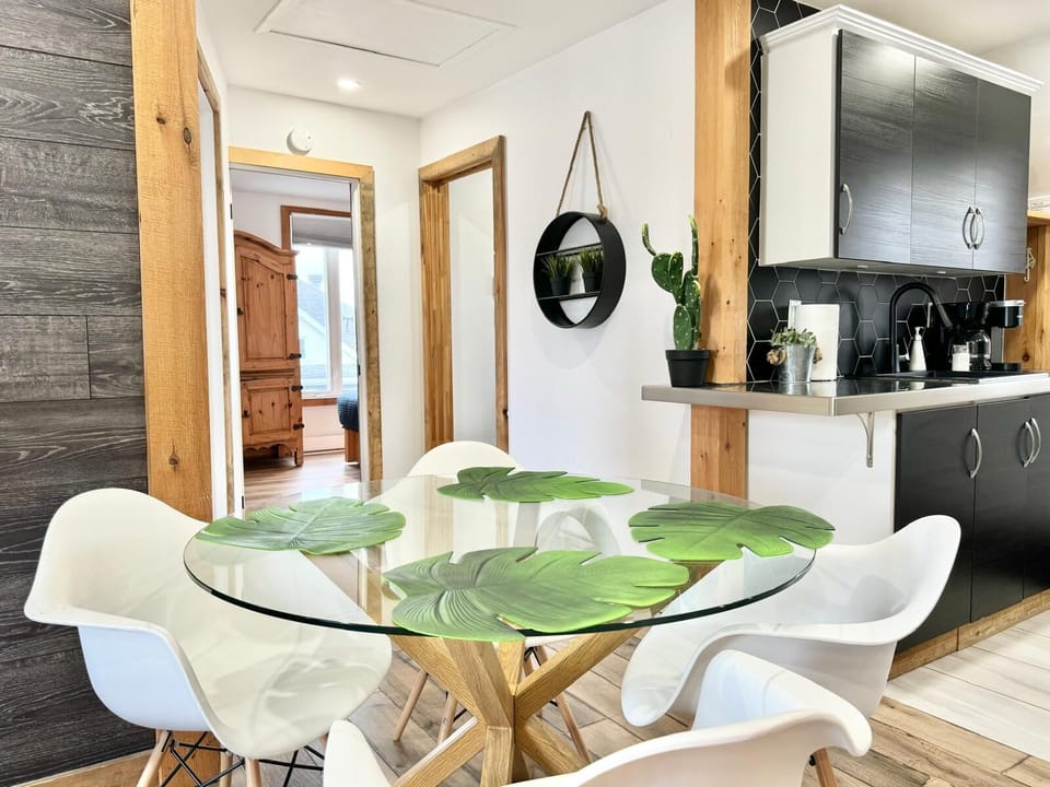 Salle à manger : l’élégance moderne rencontre la nature avec une superbe table en verre, une touche de verdure et une ambiance apaisante pour des repas mémorables.