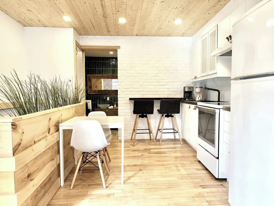 Style & confort au rendez-vous! Coin repas lumineux parfait pour vos brunchs. Design moderne et chaleureux avec plafond et murs en bois. 