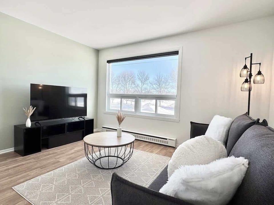 Découvrez cet espace accueillant avec de grandes fenêtres et un décor moderne, parfait pour la détente et le divertissement!