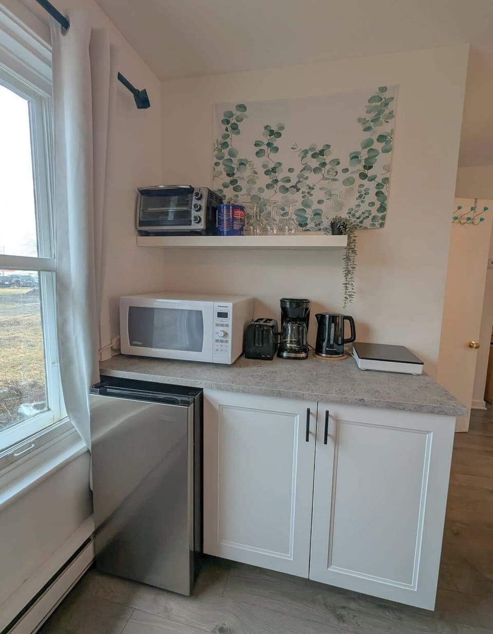 Kitchenette chaleureuse : électroménager moderne et lumière du matin pour savourer votre café en toute tranquillité.