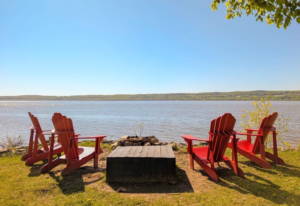 Détente avec vue imprenable! Chaises Adirondack rouges face au lac. L'endroit idéal pour un feu de camp ou un café. Votre paradis nature!