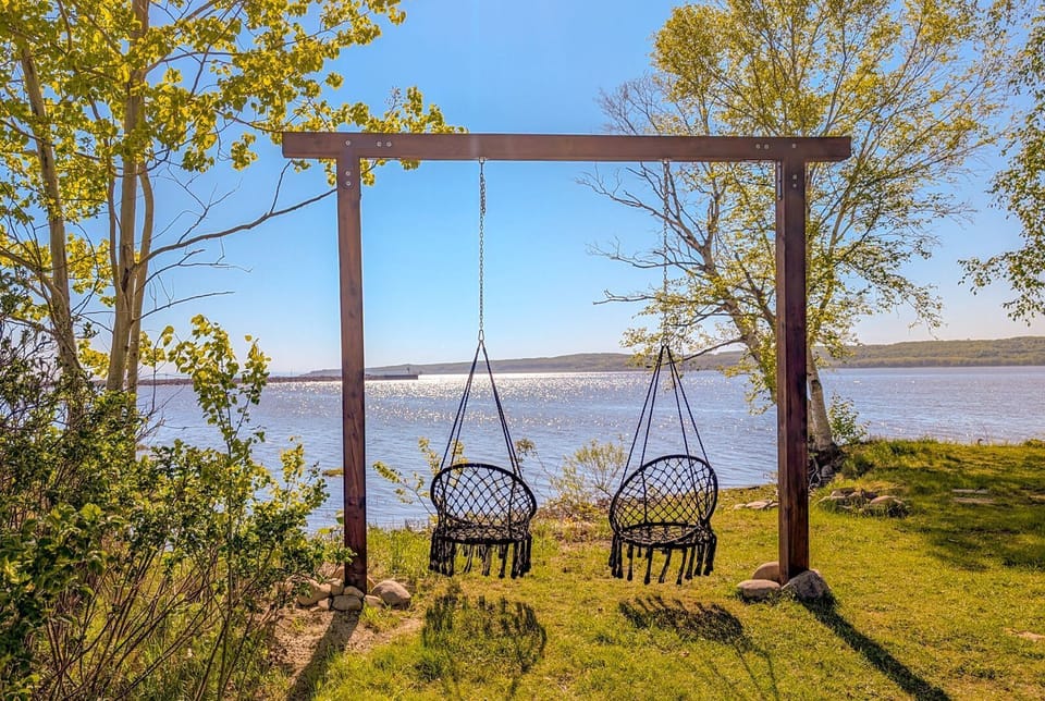 Retraite paisible au bord du lac — détendez-vous sur nos chaises suspendues et laissez la nature faire le reste.