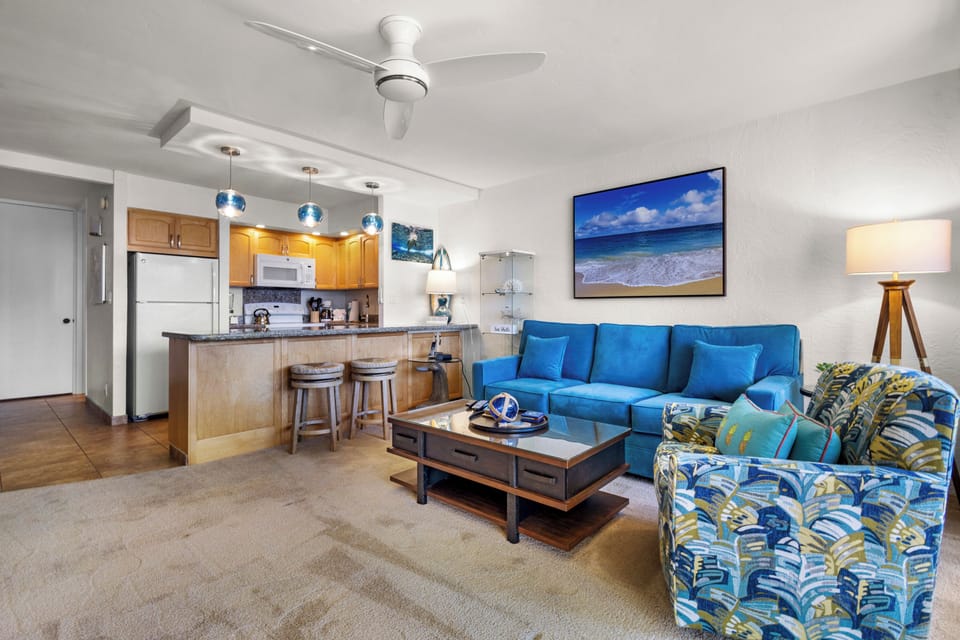Relax on plush coastal furnishings in your airy living space, complete with a full kitchen, breakfast bar seating, and ocean-inspired décor. The gentle whir of the ceiling fan sets the perfect island vibe.