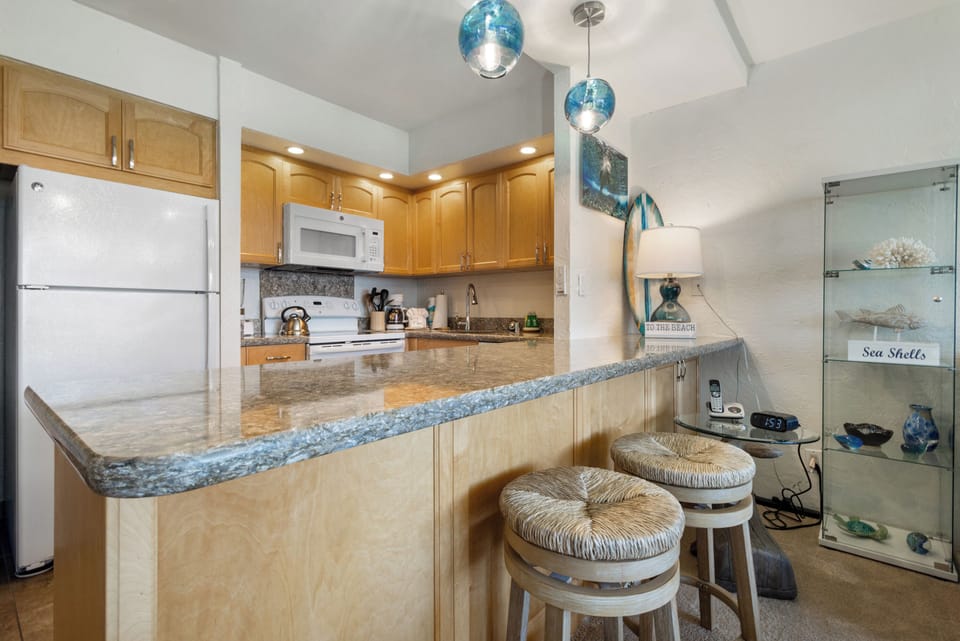 Your fully equipped kitchen features granite counters, modern appliances, and a breakfast bar—perfect for morning coffee or preparing fresh meals during your stay.