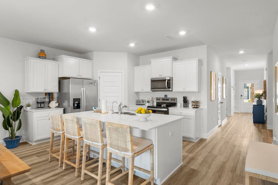 Cook your favorite meals in this bright, modern kitchen featuring crisp white cabinetry, sleek countertops, and all the appliances you need for a perfect stay.
