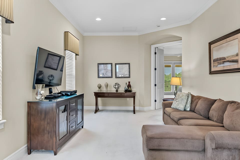 Experience a cozy living area filled with soft, neutral tones and natural light. The inviting brown couch beckons you to relax, while tasteful artwork and an elegant side table add charm—ideal for unwinding after your adventures.