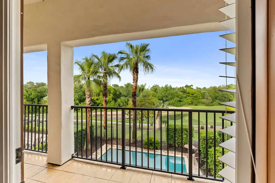 Enjoy the serene atmosphere from your private balcony, surrounded by lush greenery and palm trees overlooking the inviting pool. The warm natural light makes it the perfect spot for relaxation or your morning coffee.