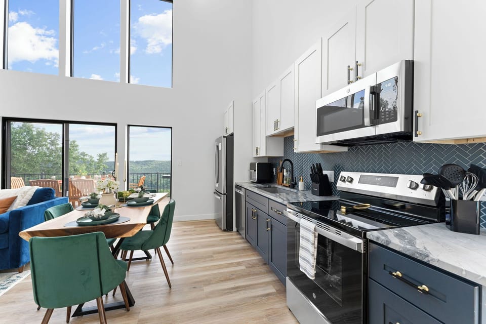 Cook and gather in this modern kitchen featuring stainless steel appliances, sleek cabinetry, and stunning views of the Ozark Mountains. Located near Silver Dollar City, Table Rock Lake, and top Branson, MO attractions—perfect for your next getaway!