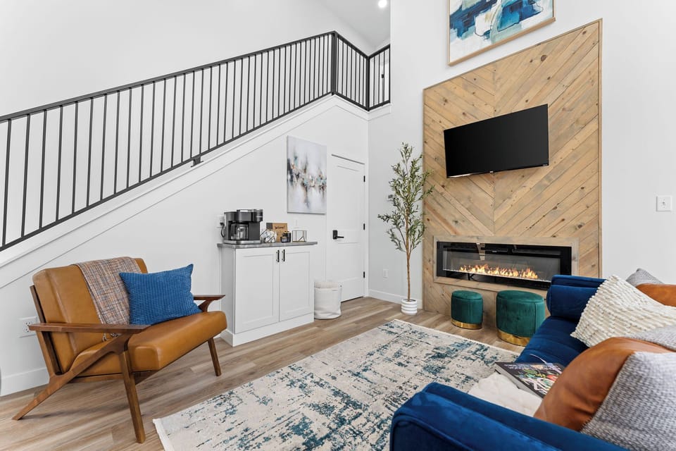 Cozy up by the modern fireplace in this beautifully designed living space at Whispering Branches by Relax and Renew Rentals. This stylish family vacation home in Branson offers comfort, charm, and space to unwind after a day of exploring local attractions.