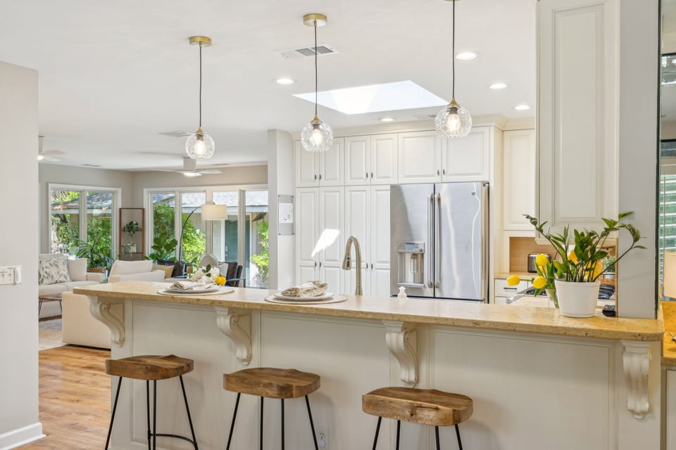 A raised breakfast bar with seating creates a natural gathering spot. An open floor plan fills the space with natural light