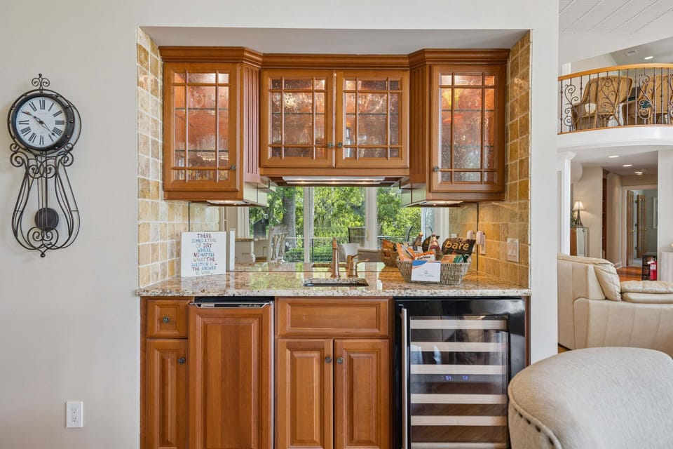 Bar area featuring upscale glassware and a wine fridge for entertaining in style.
