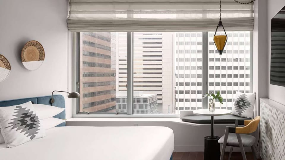 King City View - King bedroom with wide windows and skyline views of San Diego