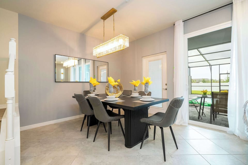 Dine in style by the light-filled window at this modern table for six, perfectly set for group meals with poolside views and elegant touches.