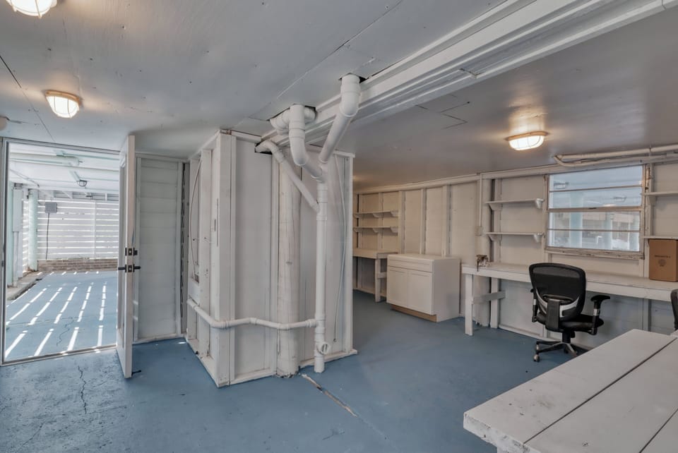 Under the carport is an enclosed area with desk space, storage and half bath