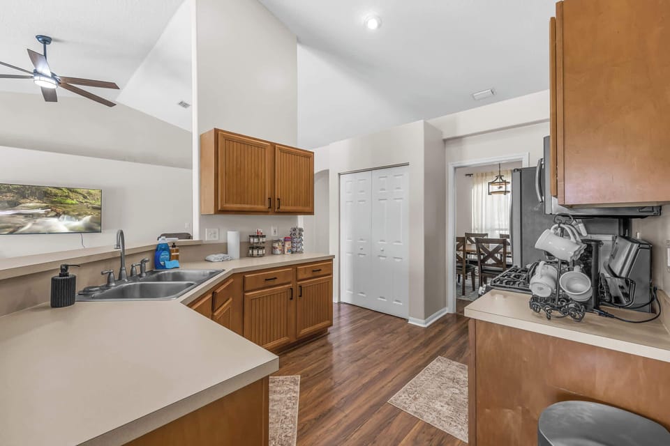 Open kitchen with wooden cabinets and modern appliances overlooking the living area.
