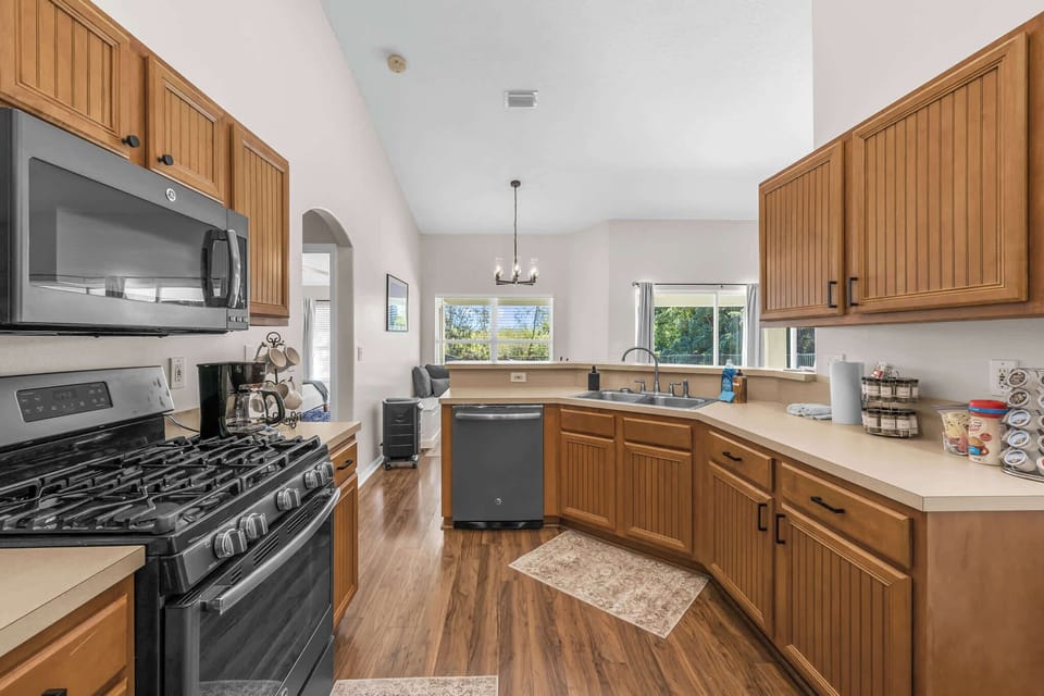 Kitchen with wooden cabinetry and modern appliances overlooking the dining area.