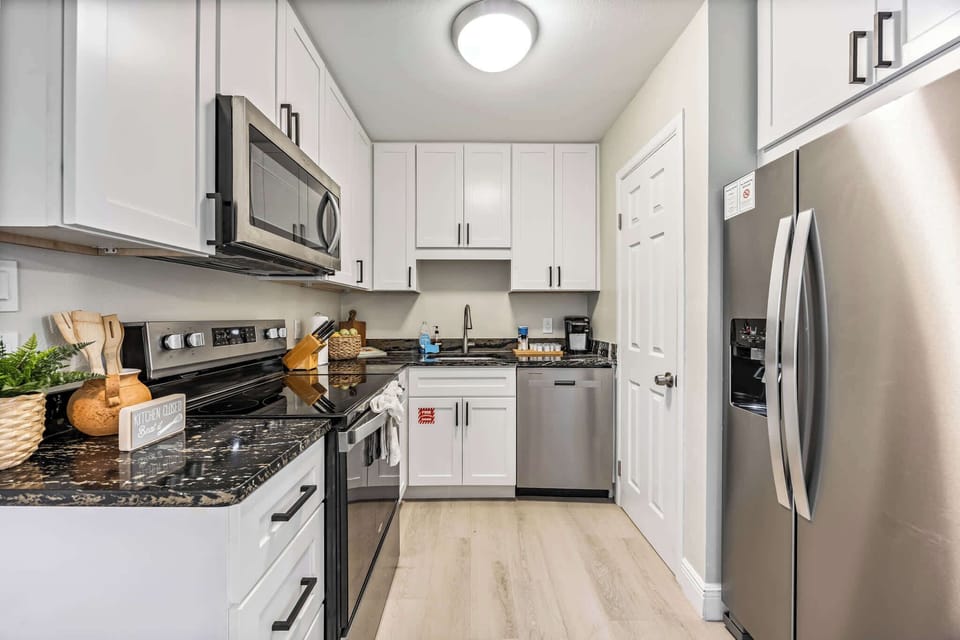 Modern kitchen with stainless steel appliances and ample white cabinetry