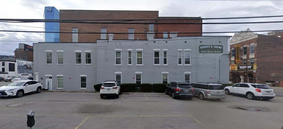 This is the parking lot on the corner that you will park in. The tall brown brick building you see in the photo is the condo building.