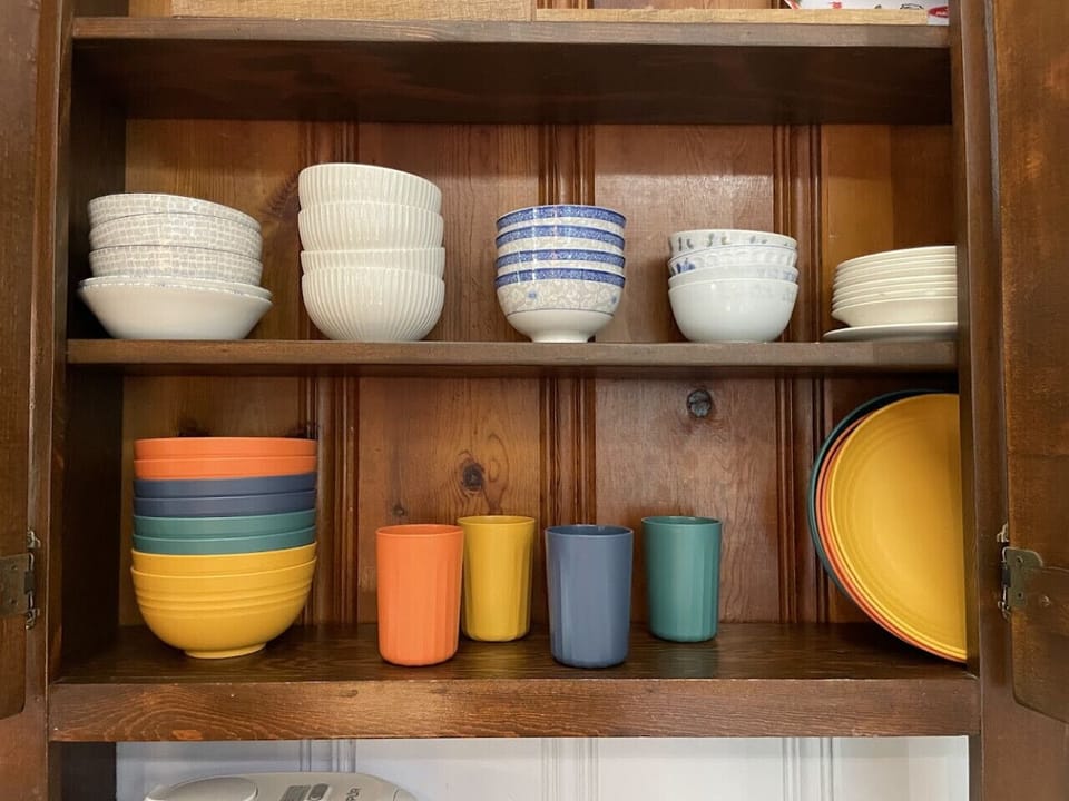 Colorful and neatly organized bowls, cups, and plates ready for your stay.
