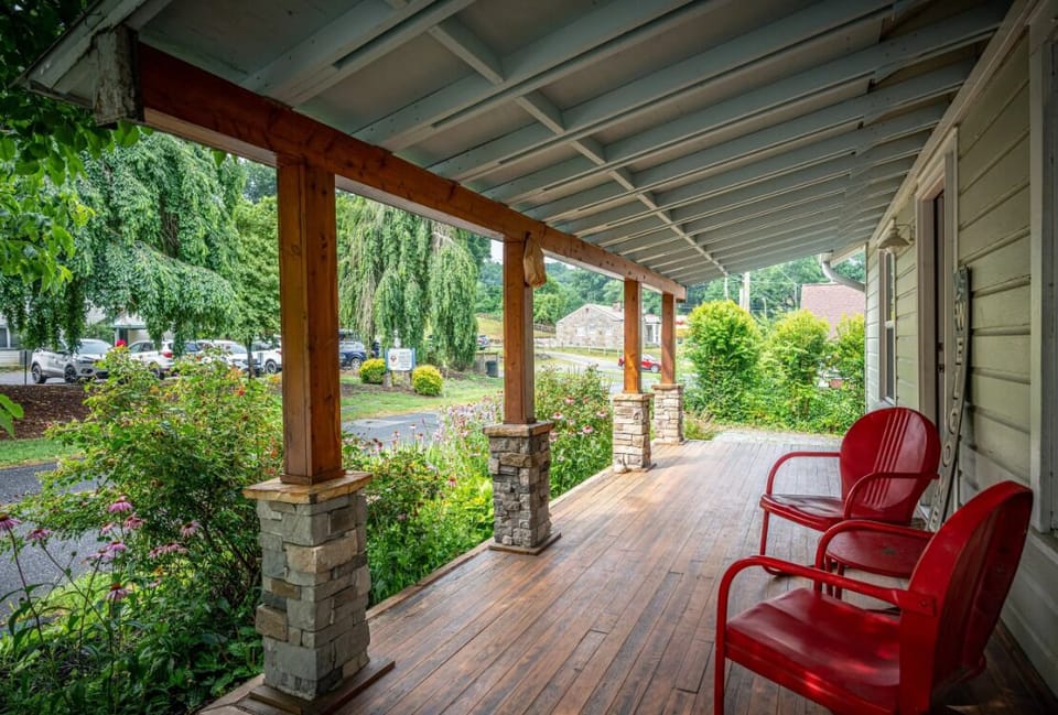 Covered front porch with red rocking chairs at BC Downtown Villa, offering a shaded outdoor space to relax and enjoy the Smoky Mountain air near downtown Bryson City.