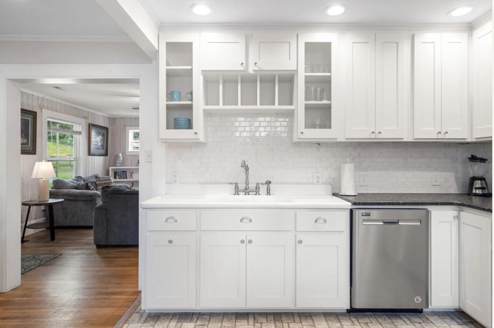 Modern kitchen with white shaker cabinets, granite countertops, and built-in wine storage at BC Downtown Villa, offering convenience and style for your Smoky Mountain stay.
