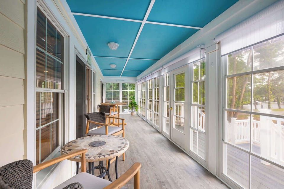 Mid Level: Enclosed back deck with plenty of seating - perfect for morning coffee or unwinding while enjoying peaceful outdoor views, with easy access to the outdoor space