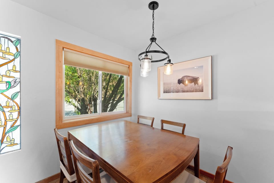Gather around this warm dining table for memorable meals with loved ones, surrounded by artistic touches and natural light.