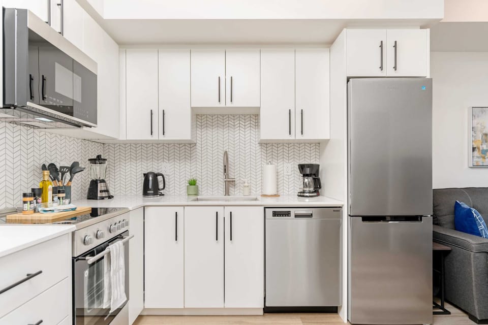 Fully Equipped Kitchen With Quartz Countertops And Stainless Steel Appliances