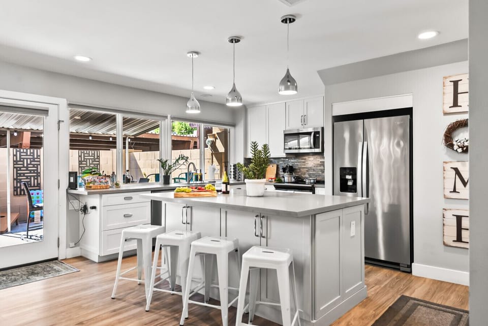 Modern Kitchen: Bright, airy space with sleek appliances and inviting bar seating for culinary adventures!