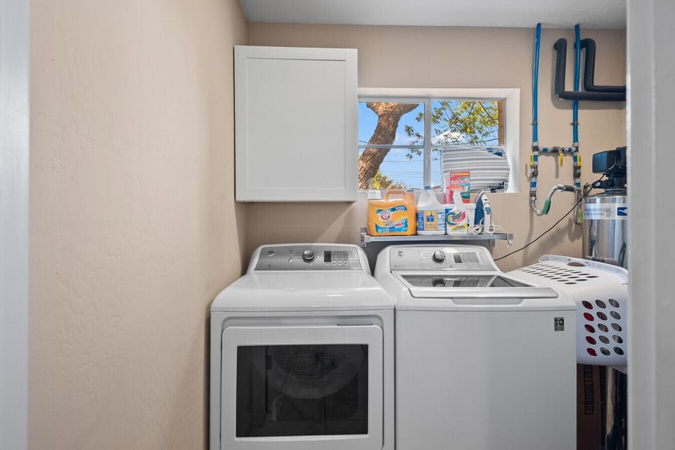 Dedicated laundry space with efficient washer and dryer machines, complemented by essential cleaning products, ensuring guests have everything they need to manage laundry with ease during their visit.