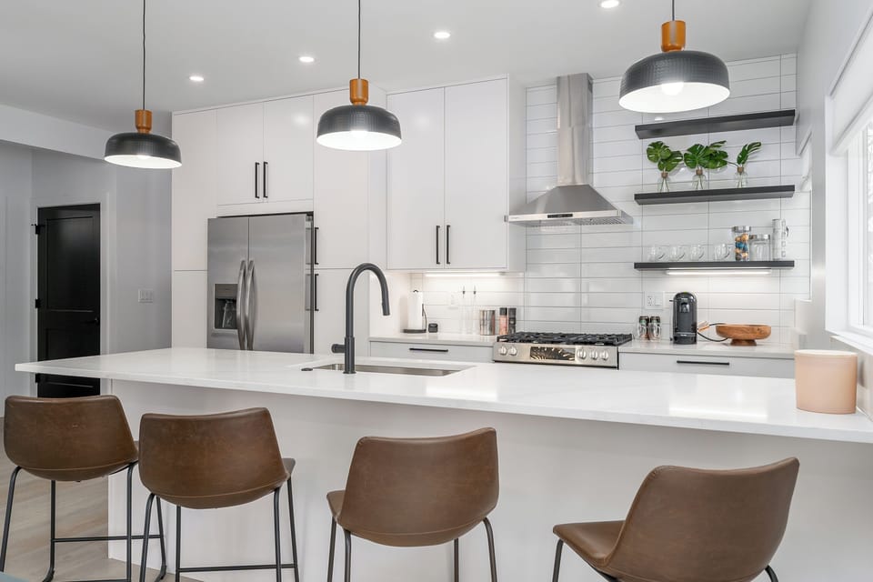 The bright, modern kitchen features full-size stainless steel appliances, generous counter space, and bar seating, making it easy to prepare meals while staying connected with family and friends.