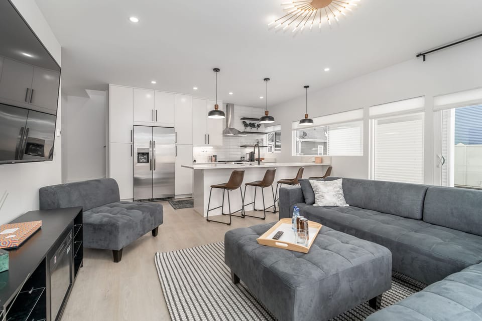 The open-concept design keeps everyone connected, whether you're preparing meals in the kitchen, enjoying drinks at the island, or relaxing in the living room nearby.