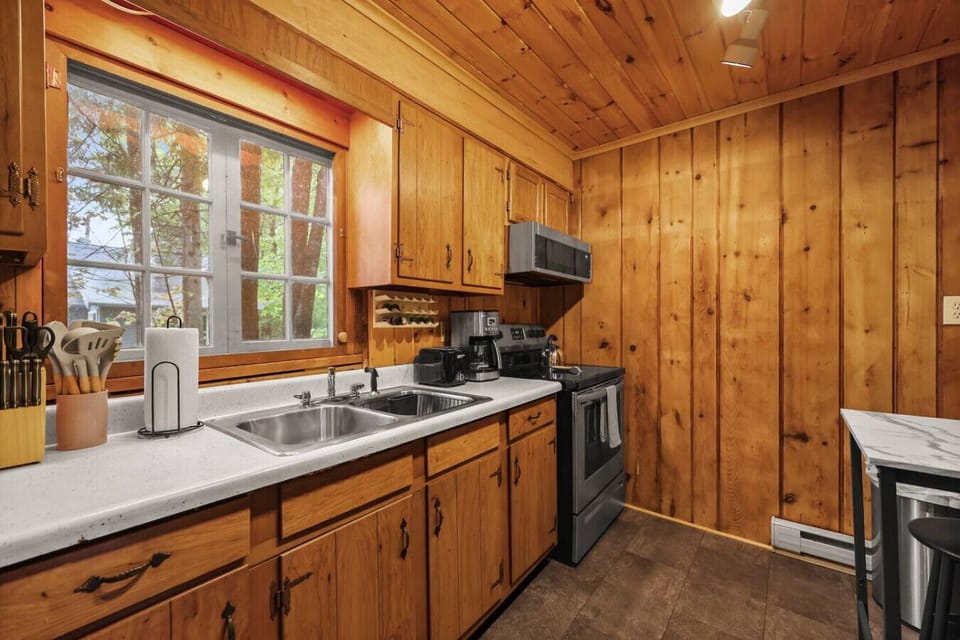 Fully equipped kitchen with wood cabinetry, modern appliances, and all the essentials for preparing delicious meals during your stay.