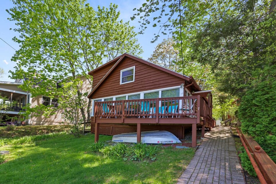 Charming cabin exterior with spacious deck and surrounding greenery.