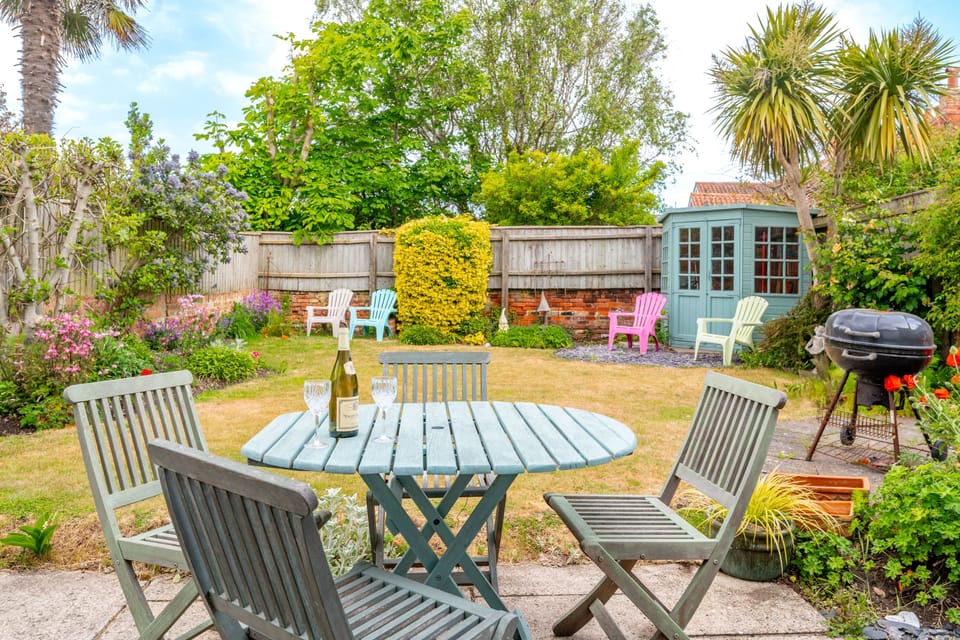 Sanderlings, Aldeburgh: Garden with a table and seating for four, four sun loungers, and a barbecue