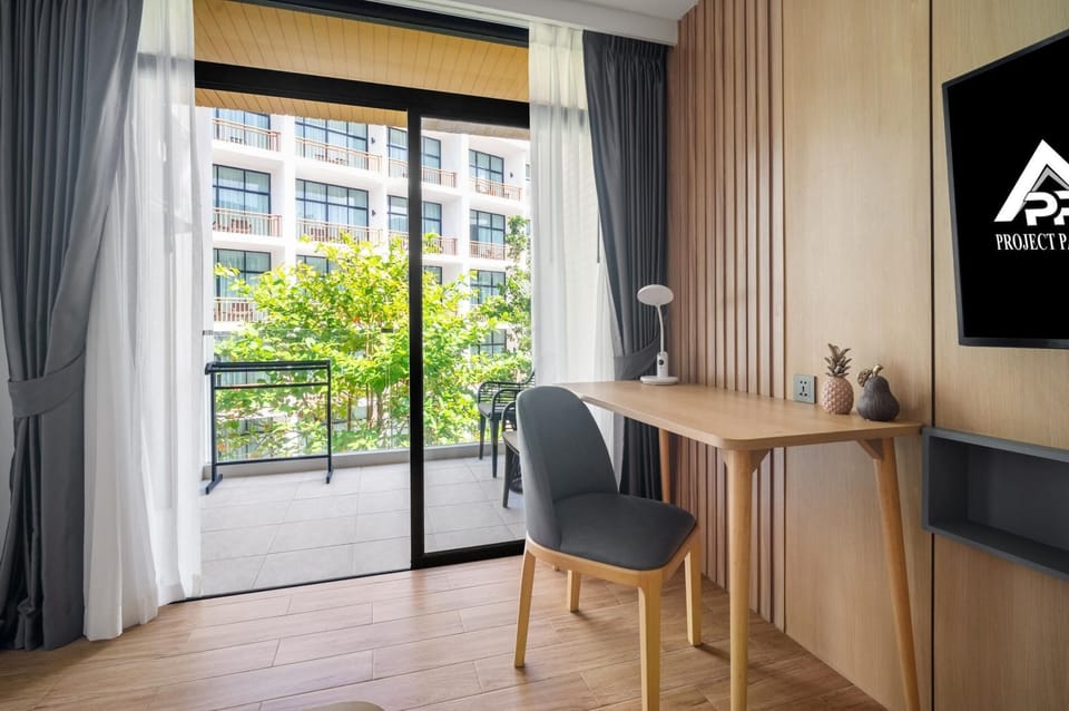 Balcony-facing workspace with desk and comfortable seating.