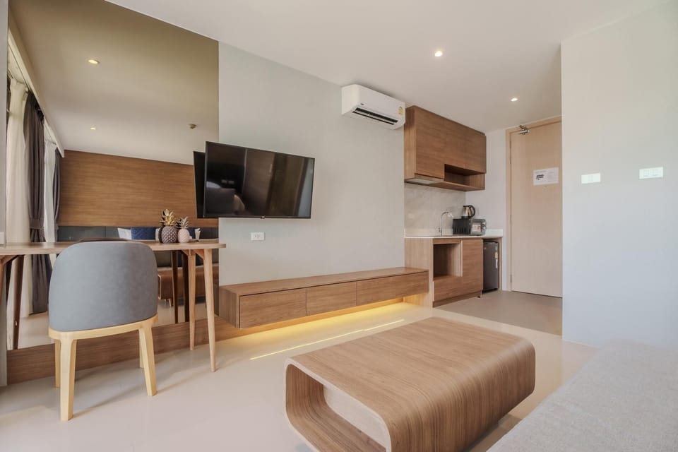 Spacious studio with king-size bed, sofa seating, bathroom, and kitchenette.
