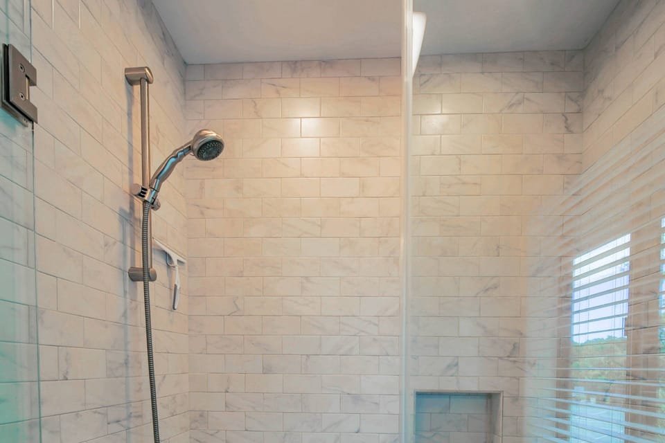 The primary en suite bathroom also has a tiled, shower/tub combo.
