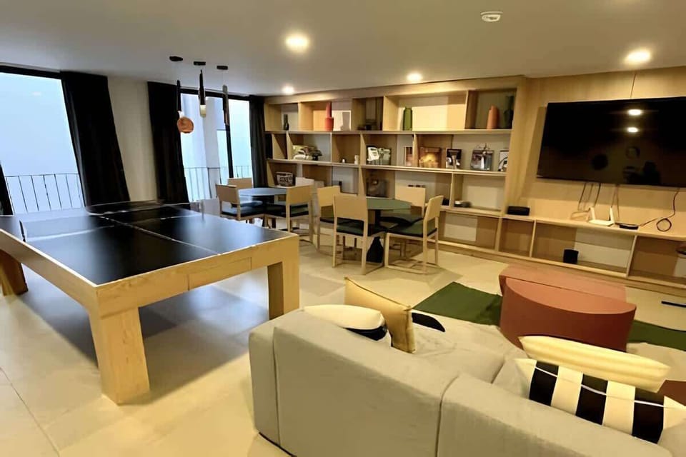 Inviting lounge space w/ sofas, warm lighting & a wall of bookshelves